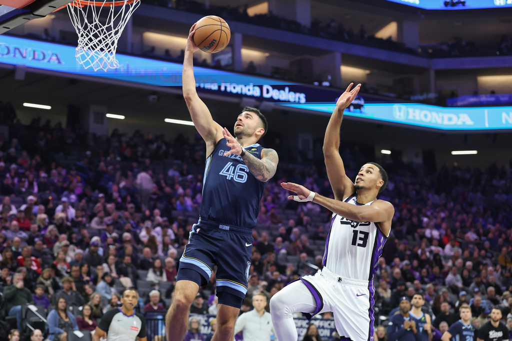 Memphis Grizzlies guard John Konchar (46) makes a layup on a fast break with Sacramento Kings forward Keegan Murray (13) defending during the first half of an NBA basketball game Sunday, Nov. 30, 2025, in Sacramento, Calif. (AP Photo/Sara Nevis)
