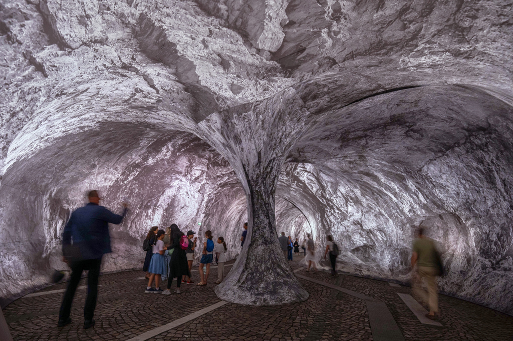 Visitors walk into the artwork "The Pont Neuf Cave" by French street artist JR on the Pont Neuf bridge, Tuesday, June 16, 2026, in Paris, open to the public from June 15 to 28. (AP Photo/Aurelien Morissard)
