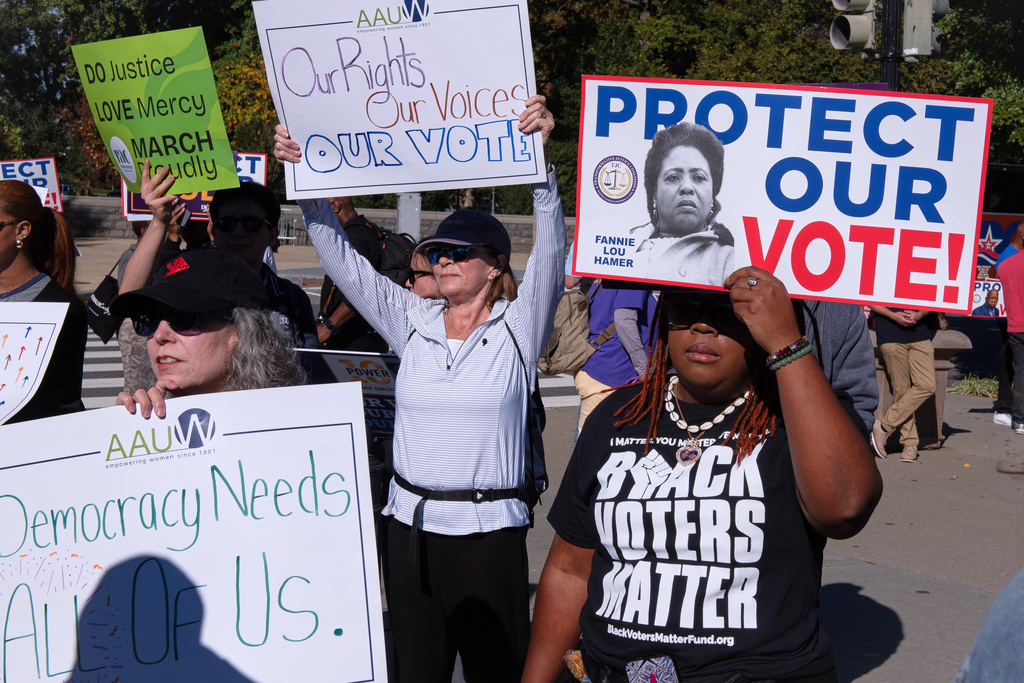 Voting rights activists gather outside the Supreme Court in Washington, early Wednesday, Oct. 15, 2025, as the justices prepare to take up a major Republican-led challenge to the Voting Rights Act, the centerpiece legislation of the Civil Rights Movement. (AP Photo/Cliff Owen)
