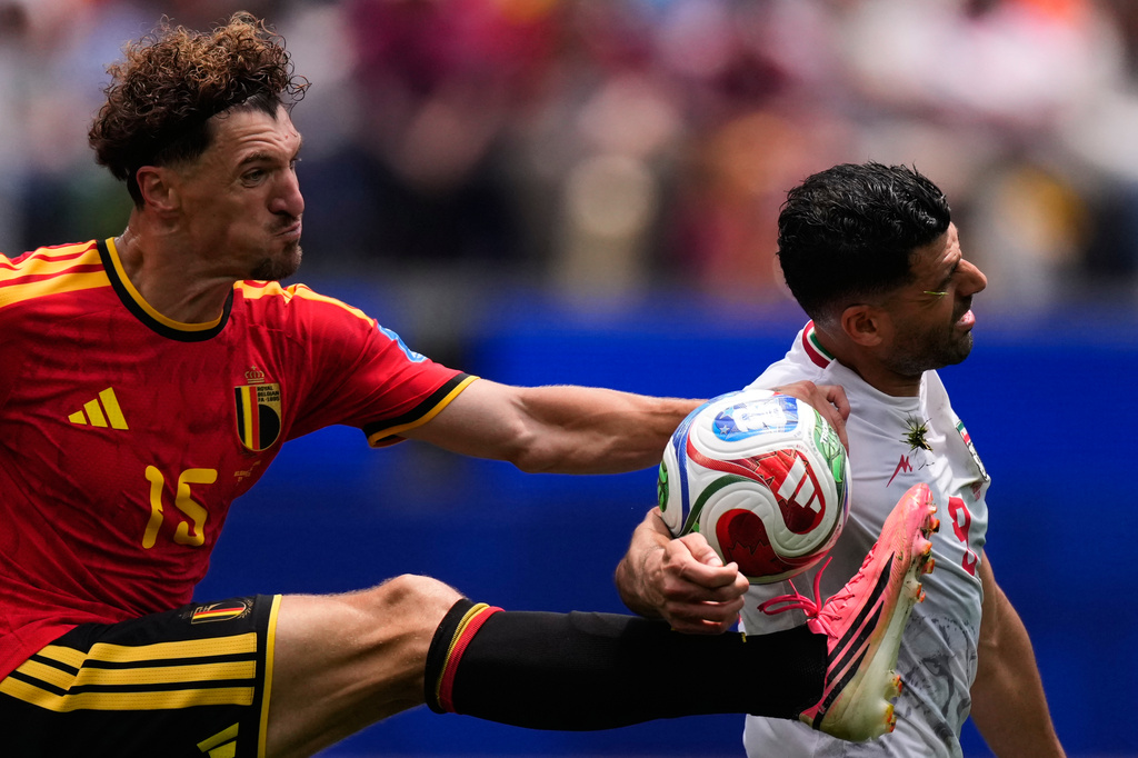 Belgium's Thomas Meunier, left, and Iran's Mehdi Taremi fight for the ball during the World Cup Group G soccer match in Inglewood, Calif., near Los Angeles, Sunday, June 21, 2026. (AP Photo/Mark J. Terrill)