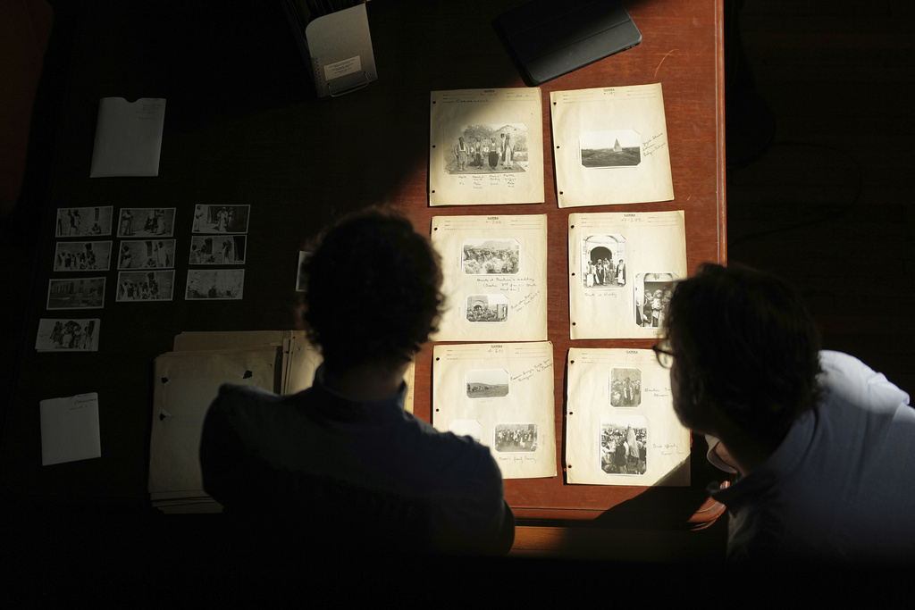 University of Pennsylvania doctoral student Marc Marin Webb, left, and University of Victoria postdoctoral fellow Nathaniel Brunt, view images of photos of the Yazidi people in their northern Iraq homeland in the 1930s, during an interview at the Penn Museum Archives in Philadelphia, Aug. 27, 2025. (AP Photo/Matt Rourke)