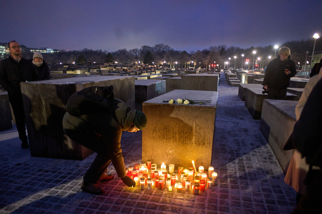 People light candles during a vigil at the Holocaust memorial on the eve of the International Holocaust Memorial Day in Berlin, Germany, Monday, Jan. 26, 2026. (AP Photo/Markus Schreiber)