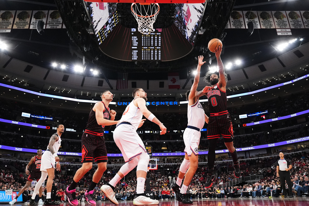 Chicago Bulls guard Coby White, right, drives to the basket against LA Clippers guard Kobe Sanders during the first half of an NBA basketball game in Chicago, Tuesday, Jan. 20, 2026. (AP Photo/Nam Y. Huh)