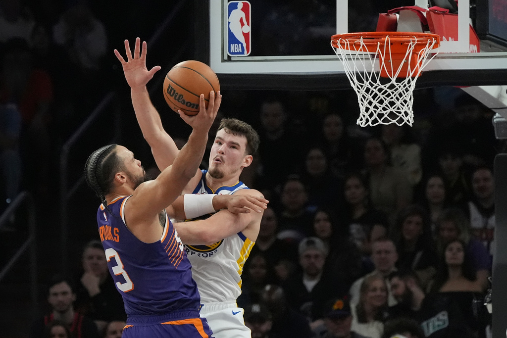 Phoenix Suns forward Dillon Brooks (3) shoots over Golden State Warriors center Quinten Post during the first half of an NBA basketball game Thursday, Dec. 18, 2025, in Phoenix. (AP Photo/Ross D. Franklin)