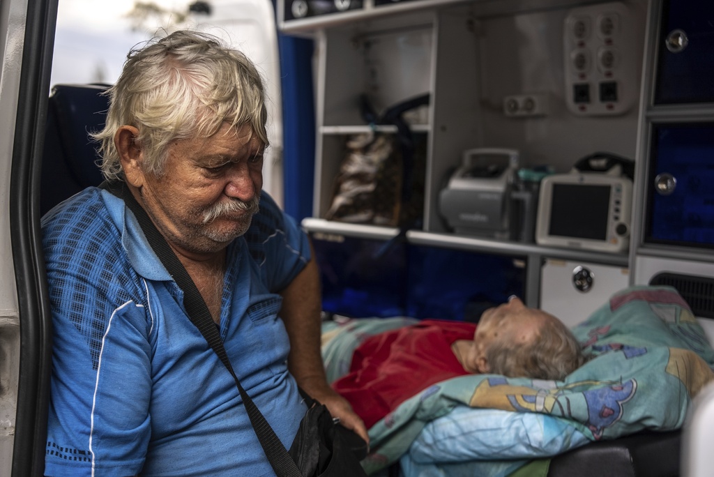 Myrola Puzyk, 70, who lost his wife Tetiana Puzyk, 68, who was killed while she was receiving her pension in the village of Yarova during a Russian aerial strike, seats in the ambulance during evacuation in Sloviansk, Donetsk region, Tuesday, Sept.9, 2025. (AP Photo/Alex Babenko)
