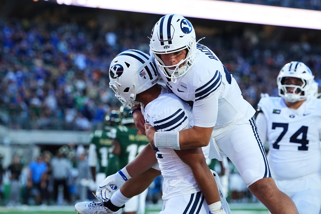 BYU quarterback Bear Bachmeier, right, jumps on running back Lj Martin after his touchdown carry against Colorado State in the first half of an NCAA college football game Saturday, Sept. 19, 2026, in Fort Collins, Colo. (AP Photo/David Zalubowski)