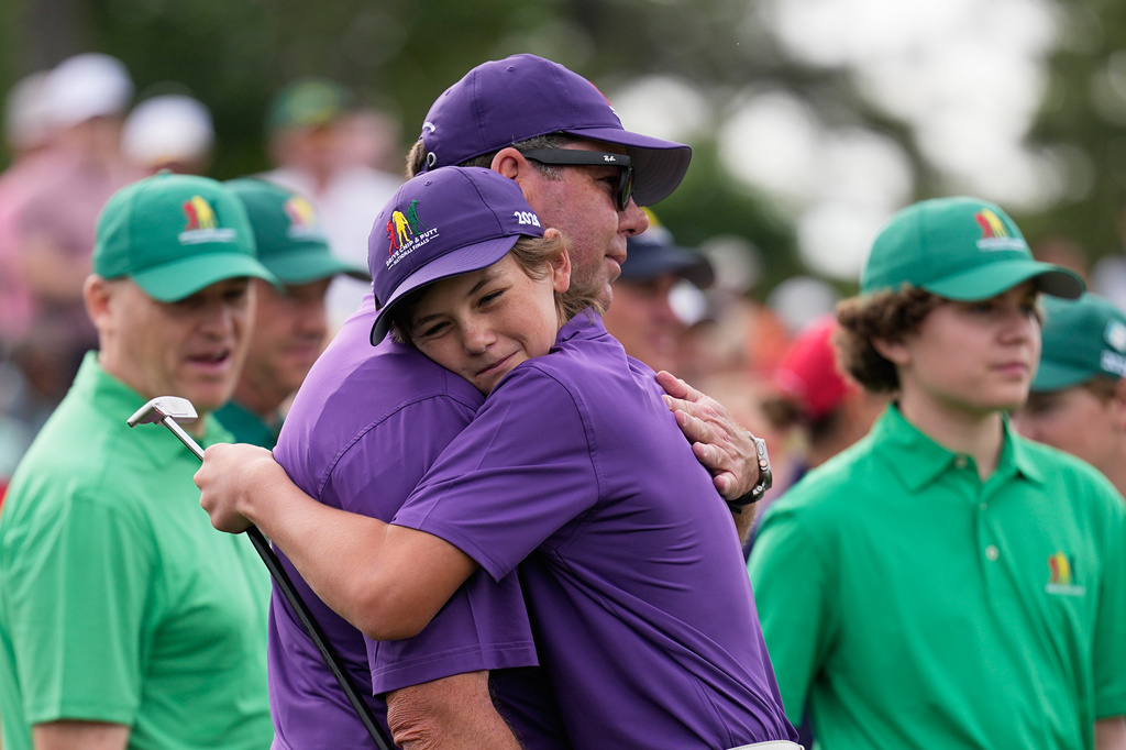 Texas Terry hugs his dad Jim, after winning the boys 12-13 bracket in the Drive Chip & Putt National Finals at the Augusta National Golf Club, Sunday, April 5, 2026, in Augusta, Ga. (AP Photo/David J. Phillip)