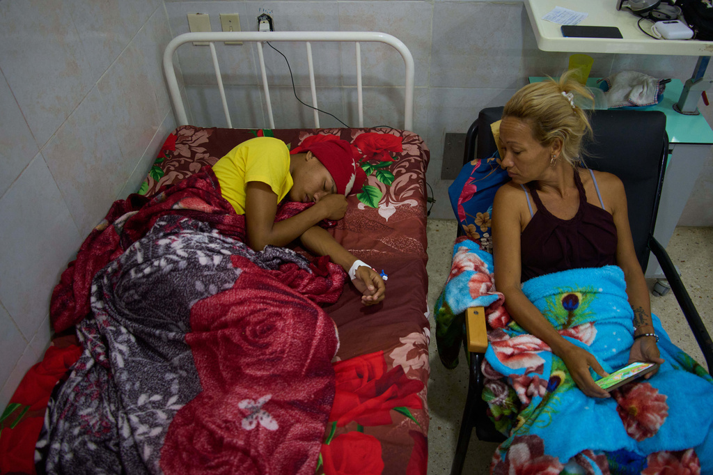 Emanuel Darian, an 18-year-old oncology patient, left, rests as his mother Katiuska Guerrero sits by his side at the National Institute of Oncology and Radiobiology in Havana, Cuba, Wednesday, June 24, 2026. (AP Photo/Ramon Espinosa)