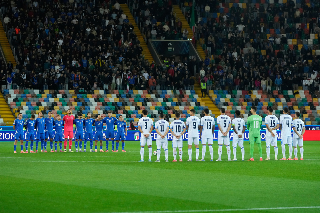 Italy's and Israel's players observe a minute of silence for the three military police officers Carabinieri dead in a explosion near Verona prior to the start of the World Cup 2026 Group I qualifying soccer match between Italy and Israel at the Bluenergy Stadium in Udine, Italy, Tuesday, Oct. 14, 2025. (AP Photo/Luca Bruno)