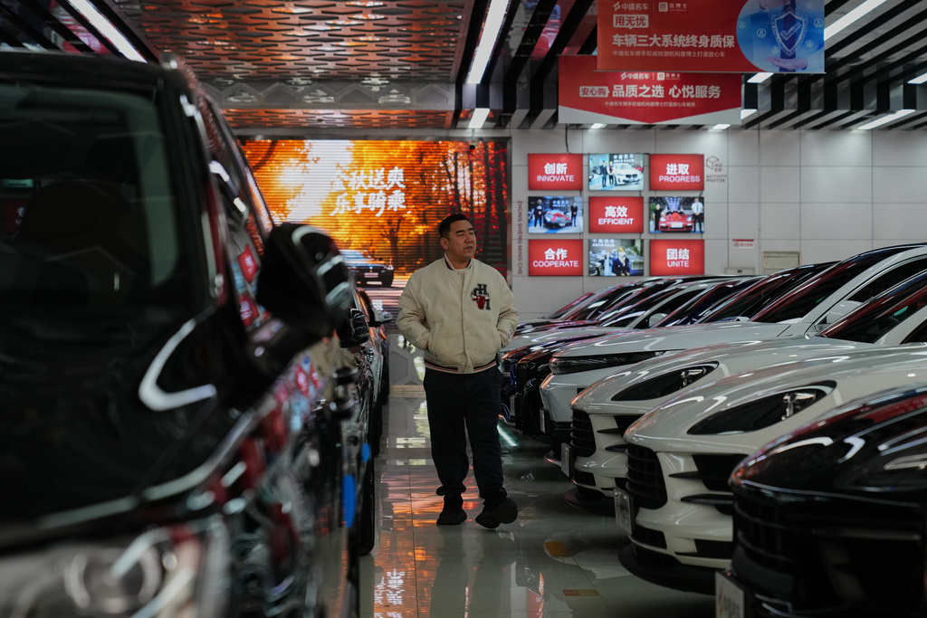 A man looks walks inside a second hand market for luxury cars in Beijing, Tuesday, Nov. 25, 2025. (AP Photo/Andy Wong)