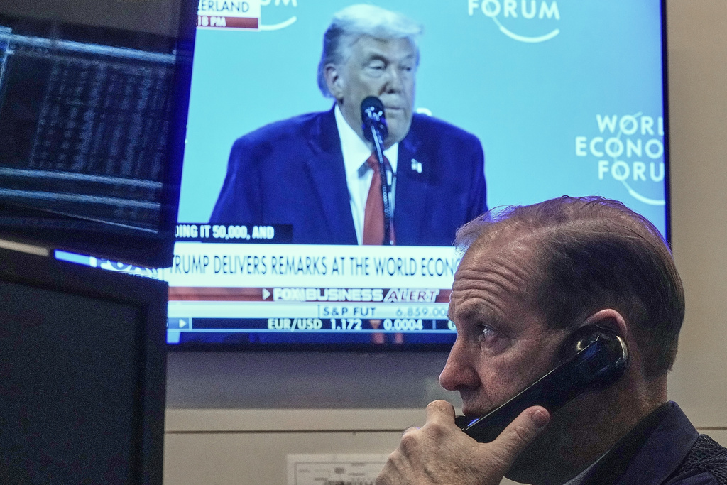 Trader Michale Smyth works on the floor of the New York Stock Exchange as President Donald Trump speaks at the World Economic Forum, Wednesday, Jan. 21, 2026. (AP Photo/Richard Drew)