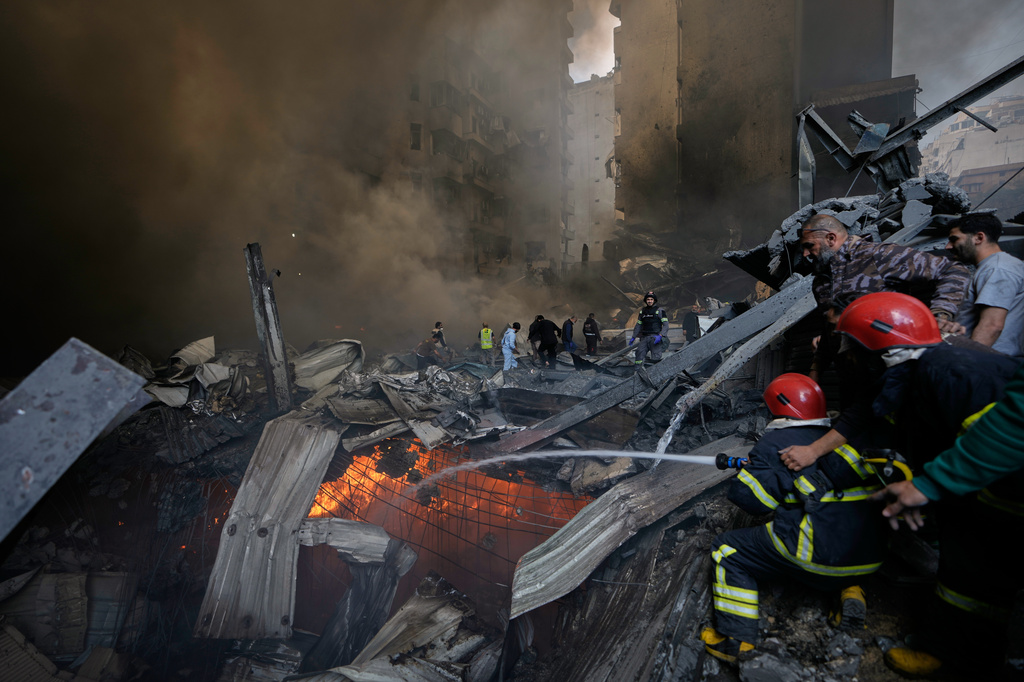 Firefighters try to put out flames at the site of an Israeli airstrike that struck an apartment building in Beirut, Lebanon, Wednesday, April 8, 2026. (AP Photo/Bilal Hussein)