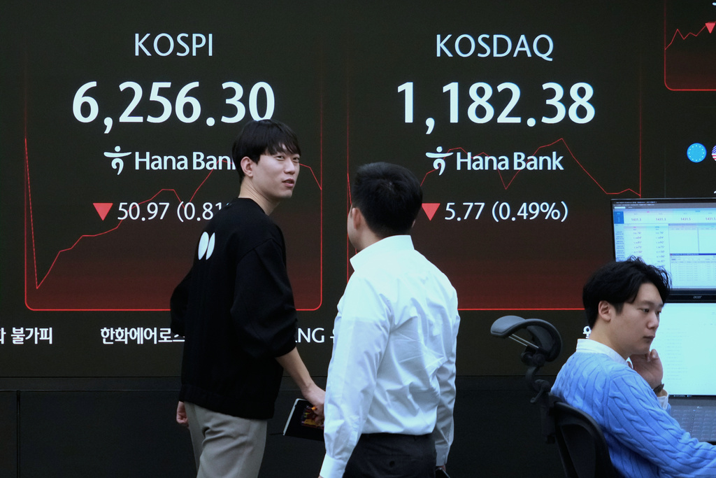 A currency trader passes by a screen showing the Korea Composite Stock Price Index (KOSPI), left, at the foreign exchange dealing room of the Hana Bank headquarters in Seoul, South Korea, Friday, Feb. 27, 2026. (AP Photo/Ahn Young-joon)