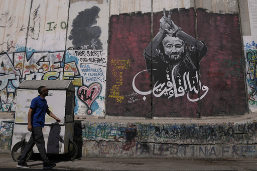 FILE - A man walks past a mural depicting the Palestinian leader Marwan Barghouti, with a message that reads in Arabic, "See you soon,” on Israel's separation barrier in the West Bank city of Bethlehem, Aug. 20, 2025. (AP Photo/Mahmoud Illean, File) FILE - A man walks past a mural depicting the Palestinian leader Marwan Barghouti, with a message that reads in Arabic, "See you soon,” on Israel's separation barrier in the West Bank city of Bethlehem, Aug. 20, 2025. (AP Photo/Mahmoud Illean, File)