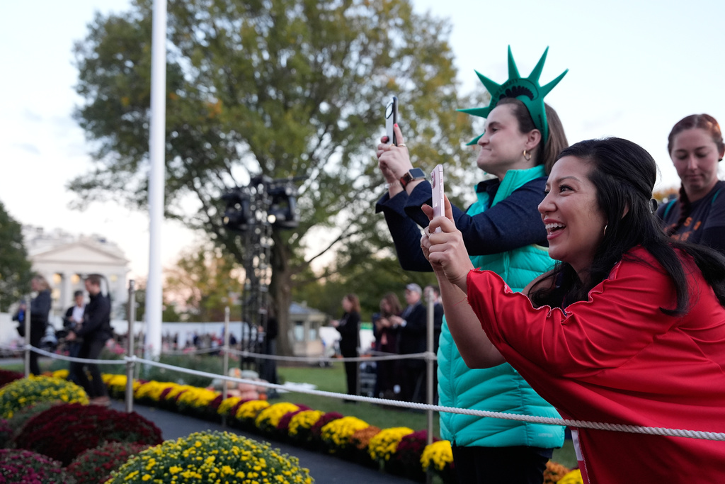 Parents take photos as President Donald Trump and first lady Melania Trump participate in a Halloween at the White House event on the South Lawn, Thursday, Oct. 30, 2025, in Washington. (AP Photo/Alex Brandon)