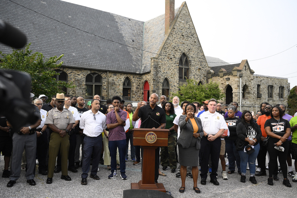 Maryland Gov. Wes Moore, center, speaks next to Baltimore mayor Brandon Scott, left center, during a news conference, Friday, Sept. 5, 2025, in Baltimore. (AP Photo/Nick Wass)
