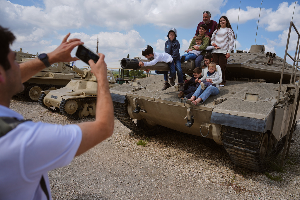 People take their photos on old tanks at the Armored Corps memorial site during a ceremony marking Israel's annual Memorial Day for the soldiers who died in the nation's conflicts and victims of nationalistic attacks, in Latrun, Israel, Tuesday, April 21, 2026. (AP Photo/Ariel Schalit)