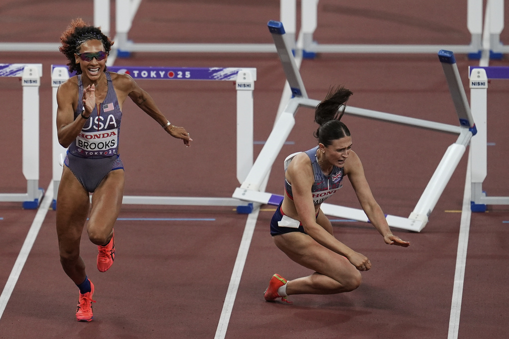 Britain's Abigail Pawlett falls as United States' Taliyah Brooks competes next to Pawlett in the heptathlon 100 meters hurdles at the World Athletics Championships in Tokyo, Friday, Sept. 19, 2025. (AP Photo/Abbie Parr)