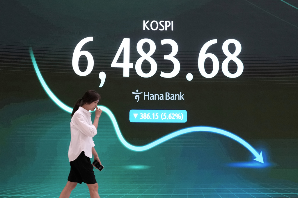 A currency trader passes by a screen showing the Korea Composite Stock Price Index (KOSPI) at the foreign exchange dealing room of the Hana Bank headquarters in Seoul, South Korea, Wednesday, Aug. 19, 2026. (AP Photo/Ahn Young-joon)