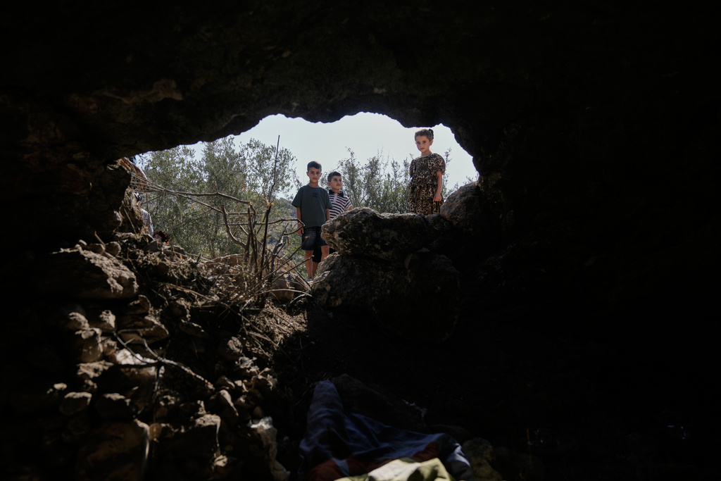 Palestinian children look at the site where Israeli police says its forces killed three Palestinian militants as they exited a cave in Kafr Qud near the West Bank town of Jenin, Tuesday, Oct. 28, 2025. (AP Photo/Majdi Mohammed)