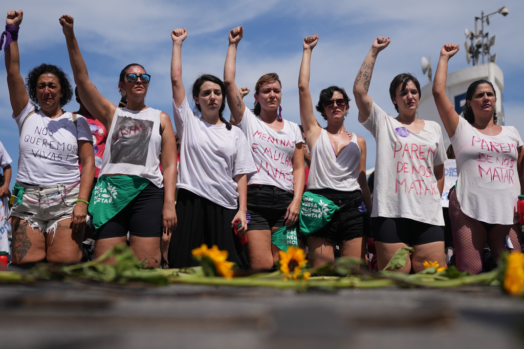 Women protest femicide following a series of high-profile cases in the country, on Copacabana beach, Rio de Janeiro, Sunday, Dec. 7, 2025. (AP Photo/Silvia Izquierdo)