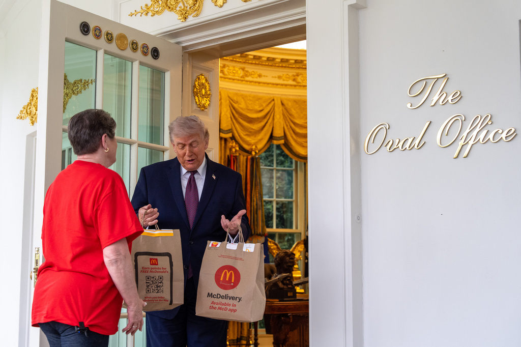Sharon Simmons with DoorDash, delivers McDonald's to President Donald Trump in the Oval Office of the White House, Monday, April 13, 2026, in Washington. (AP Photo/Alex Brandon)