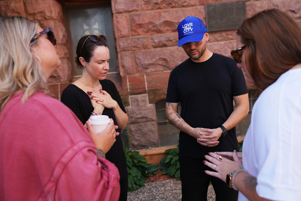 Staff from Substance Church, which neighbors Shoreline Plaza apartments, pray outside the scene of a Wednesday shooting at the building, Thursday, Sept. 3, 2026, in Minneapolis. (AP Photo/Ellen Schmidt) CORRECTION: Shoreline, not Shoreview