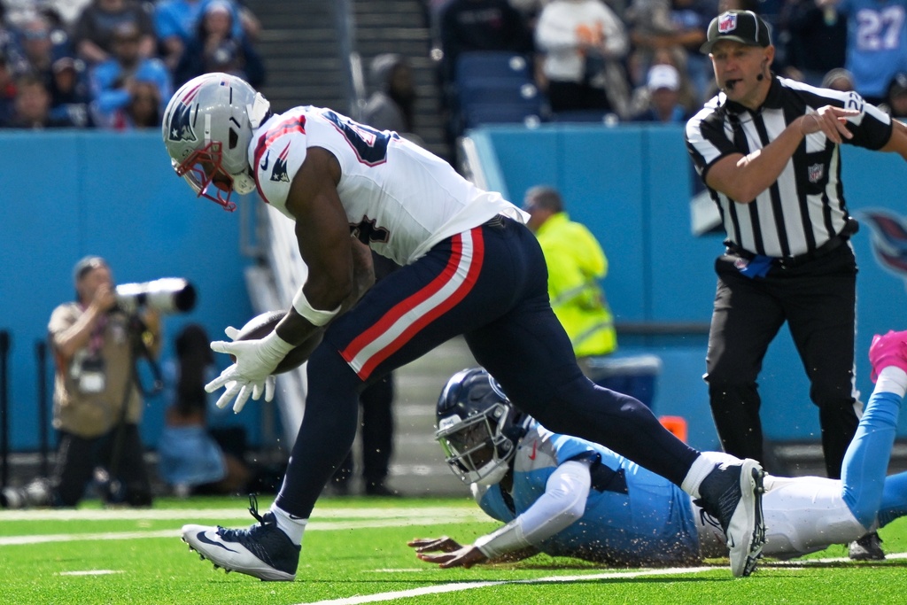 New England Patriots linebacker K'Lavon Chaisson (44) recovers a fumble by Tennessee Titans quarterback Cam Ward (1) for a touchdown during the second half of an NFL football game, Sunday, Oct. 19, 2025, in Nashville, Tenn. (AP Photo/John Amis)