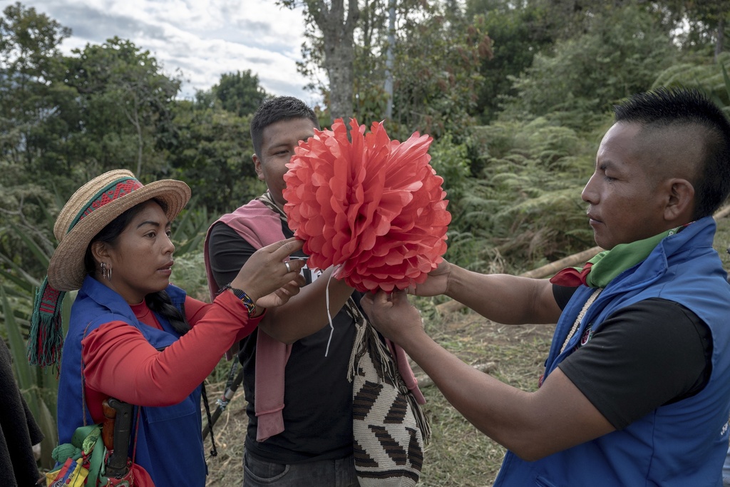 Indigenous Guards, including Patricia Elago Zetty, left, prepare decorations for a graduation ceremony on July 18, 2025, in Manuelico village, Caldono, Colombia. (AP Photo/Nadège Mazars)