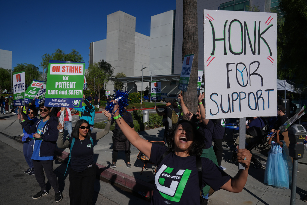 Kaiser Permanente register nurse Mia Huie, right, joins healthcare worker on strike in front of the Los Angeles Kaiser Medical Center in Los Angeles, Wednesday, Oct. 15, 2025. (AP Photo/Damian Dovarganes)