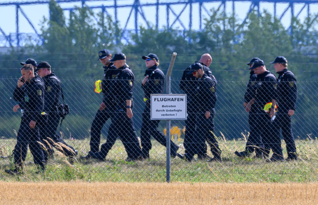 Police officers search the area away from north runway on the grounds of Leipzig/Halle Airport, where investigations are underway following the drone incident that occurred early Wednesday morning, in Schkeuditz, Germany, Thursday Aug. 6, 2026. (Hendrik Schmidt/dpa via AP)