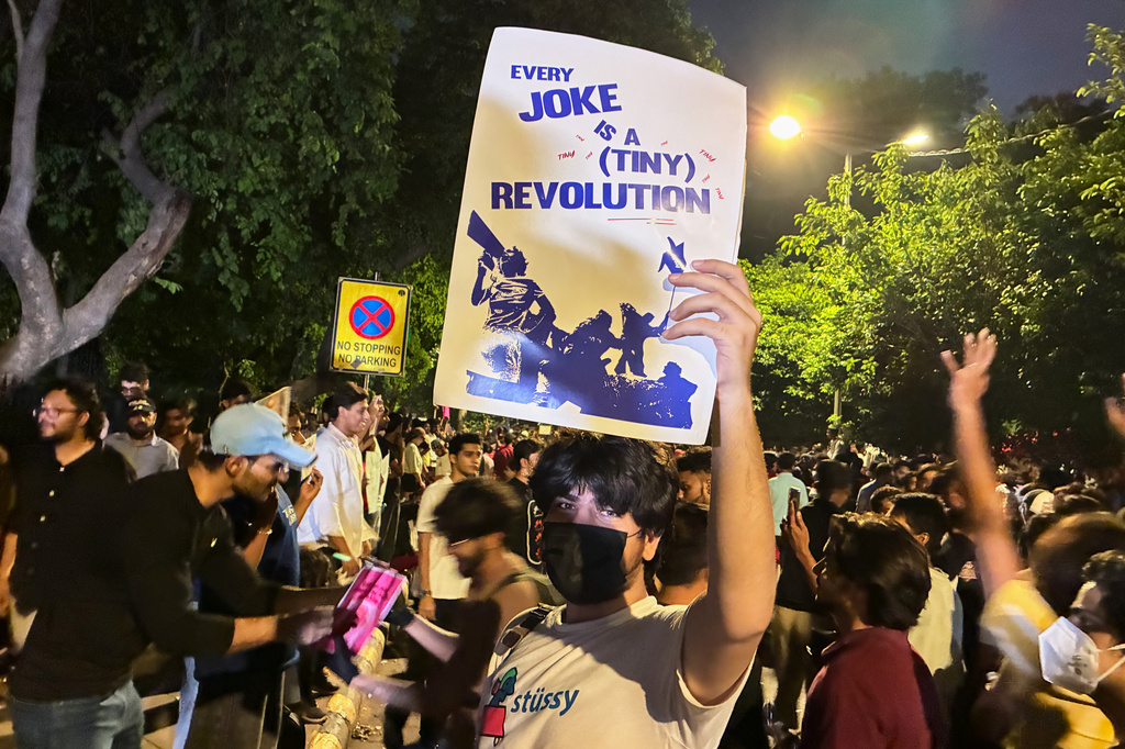 A protestor holds a placard with the message "Every Joke is a Tiny Revolution" during a demonstration demanding educational reforms as part of the Cockroach Janta Party's ongoing protest movement in New Delhi, India, Thursday, July 23, 2026. (AP Photo/Verda Subzwari)