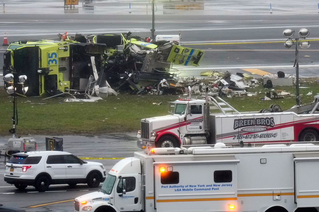 A Port Authority firetruck lays on its side just off the runway at LaGuardia Airport, Monday, March 23, 2026, after colliding with an Air Canada jet shortly after it landed late Sunday night in New York. (AP Photo/Seth Wenig)