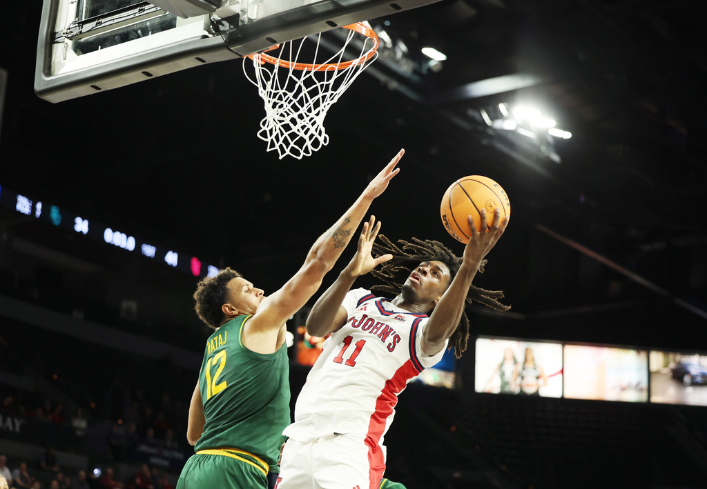 St. John's guard Ian Jackson (11) goes up for a shot near Baylor guard Michael Rataj (12) during the first half of an NCAA college basketball game Tuesday, Nov. 25, 2025, in Las Vegas. (AP Photo/Ronda Churchill)