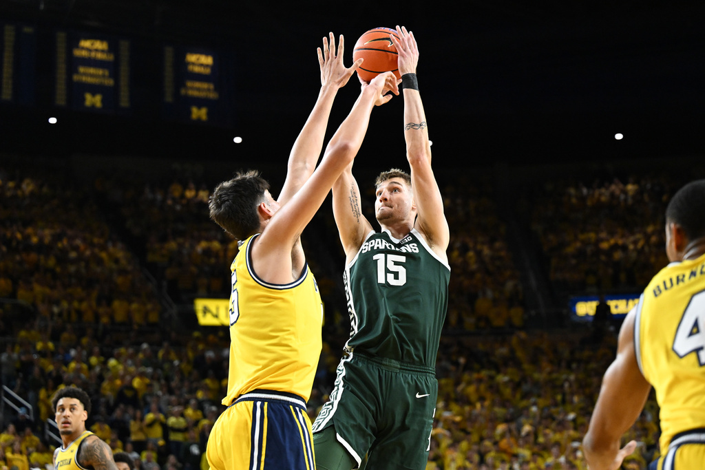 Michigan St center Carson Cooper (15) shoots the ball over Michigan center Aday Mara (15) in the first half of an NCAA college basketball game in Ann Arbor, Mich., Sunday, March 8, 2026. (AP Photo/Lon Horwedel)