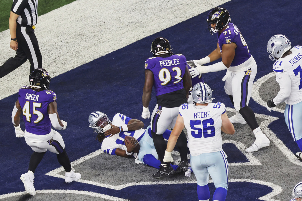 Dallas Cowboys quarterback Joe Milton III is sacked for a safety as Baltimore Ravens' Mike Green, Aeneas Peebles and C.J. Ravenell (91) look on in the first half of a preseason NFL football game Saturday, Aug. 16, 2025, in Arlington, Texas. (AP Photo/Gareth Patterson)