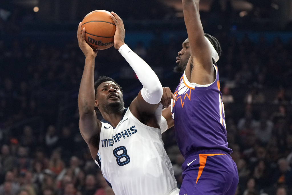 Memphis Grizzlies forward Jaren Jackson Jr. (8) shoots on Phoenix Suns center Mark Williams during the first half of an NBA basketball game, Wednesday, Oct. 29, 2025, in Phoenix. (AP Photo/Rick Scuteri)