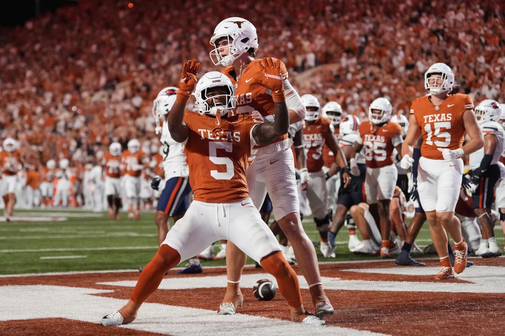 Texas running back Derrek Cooper (5) and Arch Manning, rear, celebrate after Cooper ran the ball for a touchdown during the second half of an NCAA college football game against UTSA in Austin, Texas, Saturday, Sept. 19, 2026. (AP Photo/Eric Gay)