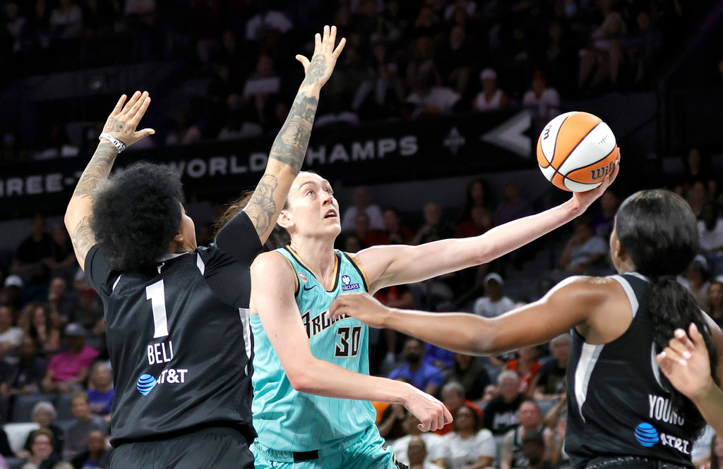 New York Liberty forward Breanna Stewart (30) shoots a layup between Las Vegas Aces forward Kierstan Bell (1) and guard Jackie Young during the first half of an WNBA basketball game Tuesday, June 23, 2026, in Las Vegas. (Steve Marcus/Las Vegas Sun via AP)
