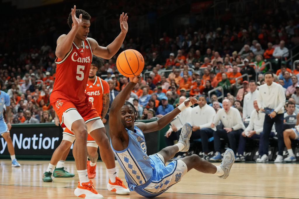 North Carolina forward Caleb Wilson (8) passes the ball after falling during the second half of an NCAA college basketball game against Miami, Tuesday, Feb. 10, 2026, in Coral Gables, Fla. (AP Photo/Marta Lavandier)