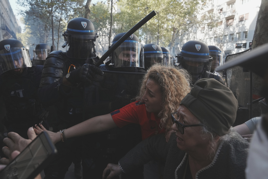 Police officers face protesters during a demonstration called by major trade unions to oppose budget cuts, in Paris, France, Thursday, Sept. 18, 2025. (AP Photo/Thibault Camus)