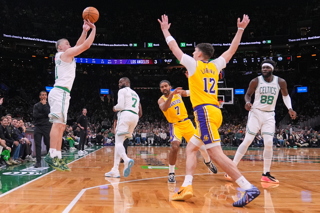 Boston Celtics guard Payton Pritchard, left, takes a 3-point shot against the Los Angeles Lakers during the first half of an NBA basketball game, Friday, Dec. 5, 2025, in Boston. (AP Photo/Charles Krupa)