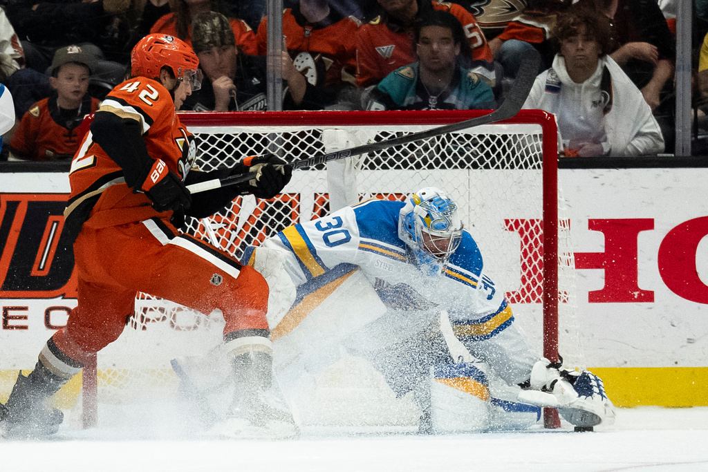 St. Louis Blues goaltender Joel Hofer, right, freezes the puck in front of Anaheim Ducks center Tim Washe during the second period of an NHL hockey game, Sunday, March 8, 2026, in Anaheim, Calif. (AP Photo/Kyusung Gong)