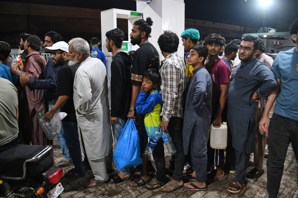 People stand in a queue at a filling station as they wait to fill their containers with gas in Karachi, Pakistan, Thursday, April 2, 2026. (AP Photo/Ali Raza)