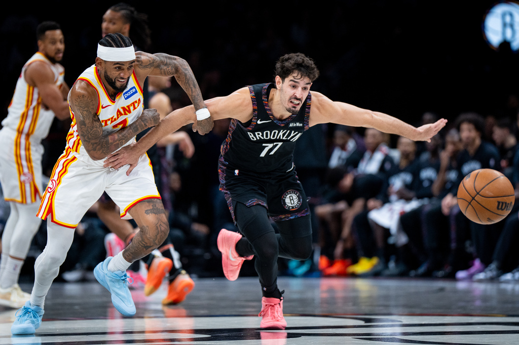 Atlanta Hawks guard Nickeil Alexander-Walker (7) and Brooklyn Nets guard Ben Saraf (77) race for the ball during the first half of an NBA basketball game, Friday, April 3, 2026, in New York. (AP Photo/Angelina Katsanis)