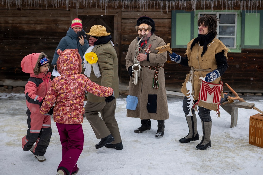 Revelers wearing traditional carnival masks dance during Shrovetide celebrations in the village of Rumsiskes, some 89 kilometers (56 miles) north of Vilnius, Lithuania, Saturday, Feb. 14, 2026. (AP Photo/Mindaugas Kulbis)