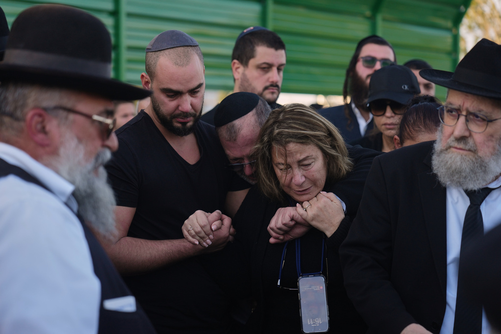 Annie, center, is comforted during the funeral of her son Dan Elkayam, a young French Jewish man who was killed in the mass shooting that targeted a Hanukkah celebration on Sydney's Bondi Beach in Australia, in Ashdod, Israel, Thursday, Dec. 25, 2025. (AP Photo/Ariel Schalit)