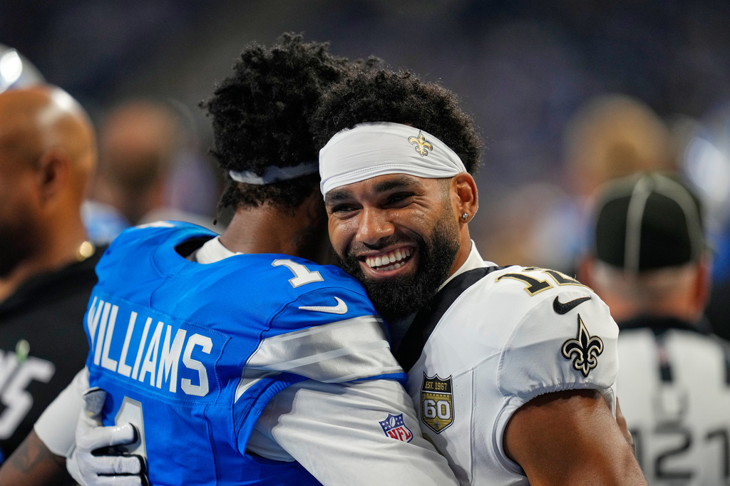 Detroit Lions wide receiver Jameson Williams hugs New Orleans Saints wide receiver Chris Olave (12) before an NFL football game, Sunday, Sept. 13, 2026, in Detroit. (AP Photo/Paul Sancya)