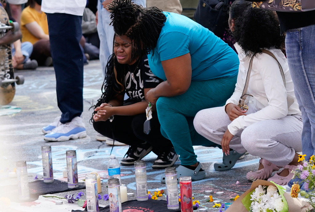 People mourn near a memorial at the site where a man was shot and killed on Wednesday by Madison police, Thursday, July 23, 2026, in Madison, Wis. (AP Photo/Kayla Wolf)