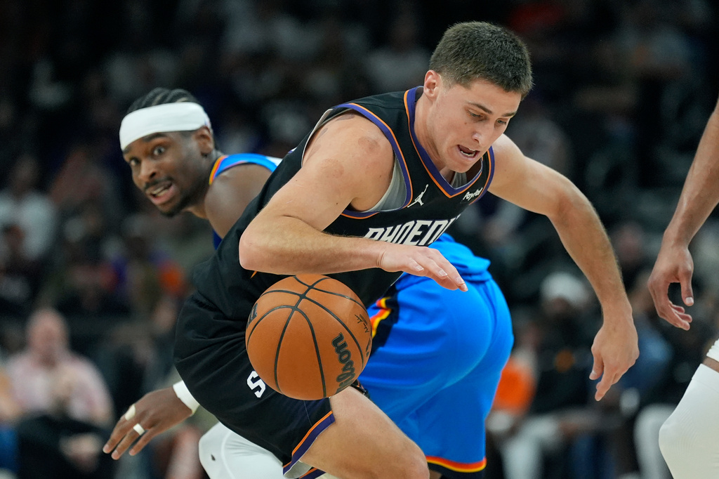Phoenix Suns guard Collin Gillespie, right, regains control of the ball against Oklahoma City Thunder guard Shai Gilgeous-Alexander during the first half of Game 4 in a first-round NBA playoffs basketball series, Monday, April 27, 2026, in Phoenix. (AP Photo/Ross D. Franklin)